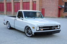 a white truck parked in front of a brick building