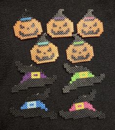 six perler beads with pumpkins and witches in them on a black surface,