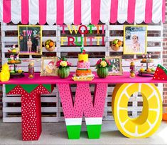 a table topped with lots of colorful food and desserts next to a sign that says wow