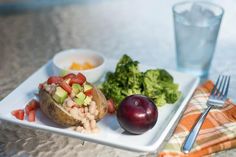 a white plate topped with food next to a glass of water