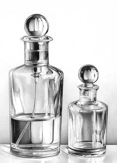 two glass bottles sitting on top of a table next to each other and one is empty