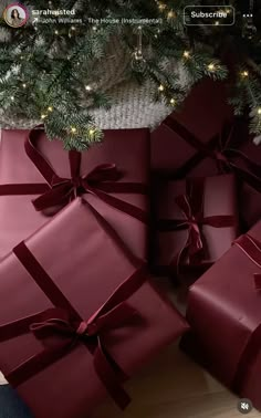 several wrapped presents under a christmas tree with lights on the top and bottom, all in red