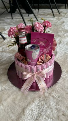 a pink gift basket on a table with flowers