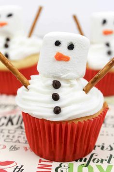 cupcakes with frosting and marshmallows on them are decorated like snowmen