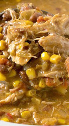 a spoon full of soup with corn and meat