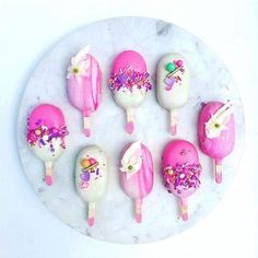 there are many pink and white ice creams on the plate with sprinkles