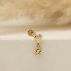 a gold heart and star earring with a diamond