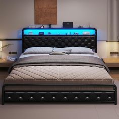 a bed with a black headboard and blue lights on the night stand above it