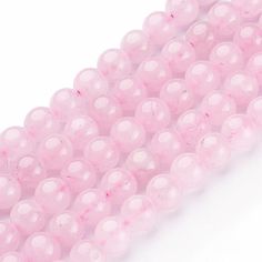 pink beads are lined up on a white surface