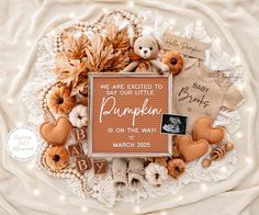 a baby announcement surrounded by pumpkins and other items on a lace doily with the words, we are excited to say our little pumpkin is on the way