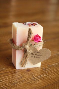 a soap bar with a pink rose on it sitting on a wooden table next to a tag that says from my shower to yours