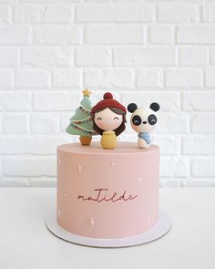 a pink cake decorated with two pandas and a christmas tree on top that says nottie