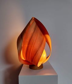 an orange lamp sitting on top of a white block