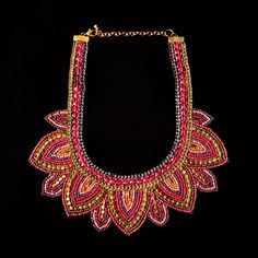 a red and gold necklace on a black background