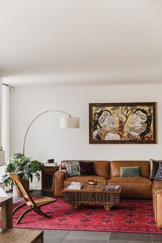 a living room filled with furniture and a painting on the wall