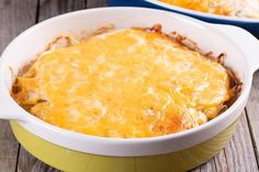 a casserole dish with meat and cheese in it sitting on a wooden table