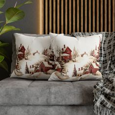 two pillows sitting on top of a couch next to a plant