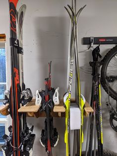 some skis and snowboards are hanging on the wall