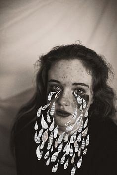 a black and white photo of a woman with freckles on her face covering her eyes