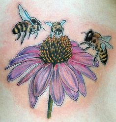 a woman's back with three bees on it and a flower in the middle