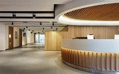 an empty lobby with wood paneling on the ceiling and lights hanging from the ceiling