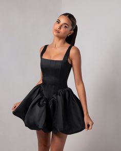 Introducing the Black Corset Sheen Mini Bubble Dress, a statement piece that exudes bold elegance and modern glamour. Crafted from our luxurious, runway-inspired sheen fabric, this dress catches the light beautifully, giving it a rich, polished look. The structured corset bodice cinches the waist to create an alluring hourglass silhouette, while offering impeccable support and comfort. The dramatic bubble skirt adds volume and a playful touch, making this mini dress a true standout. Perfect for