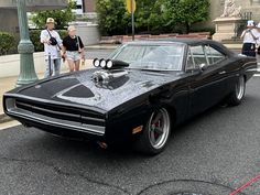 a black muscle car parked on the street