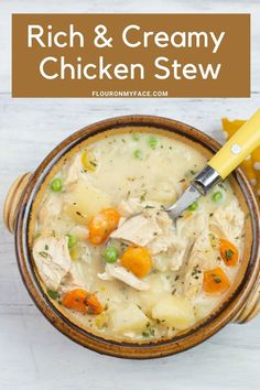 a bowl filled with chicken and cream soup on top of a white table next to a yellow spoon