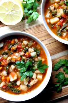 two bowls of vegetable soup on a cutting board