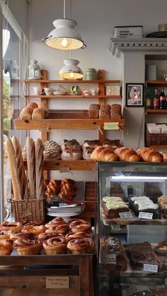 a bakery filled with lots of different types of breads and pastries on display