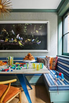 a room with blue and white striped benches, yellow chairs and a painting on the wall