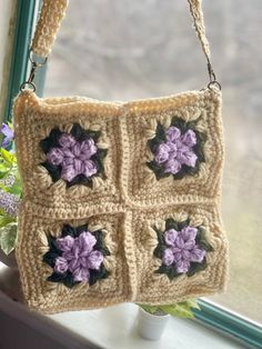 a crocheted purse hanging from a window sill