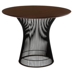 the table is made out of metal and has an oval wooden top with black wire