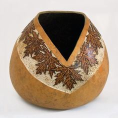 a wooden vase with leaves painted on it