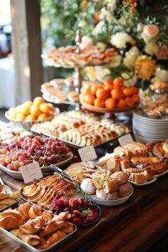 a table filled with lots of different types of pastries on plates and trays