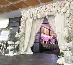 the entrance to a wedding ceremony decorated with white and pink flowers