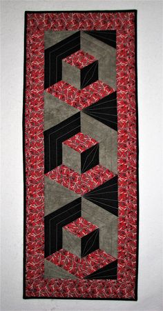 a red and black quilted wall hanging