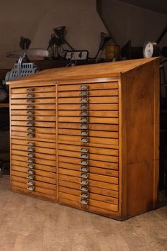 a large wooden cabinet with many drawers on it's sides, in a room