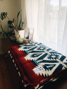 a blanket on a table next to a potted plant