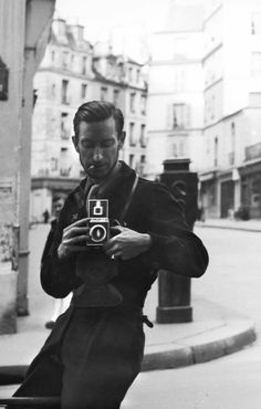 a man is taking a photo on his cell phone in the middle of the street