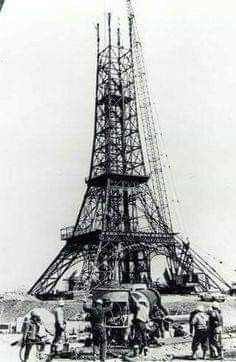 an old black and white photo of people standing in front of the eiffel tower