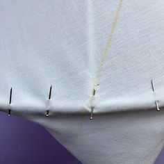 the sewing needle has been stitched into the fabric with two different pins on it