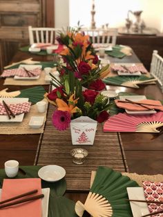 the table is set with plates, napkins and flowers