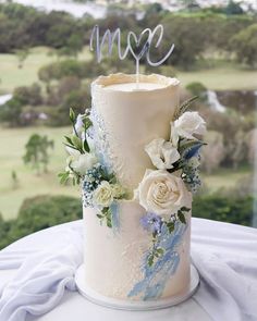 a white wedding cake with blue and white flowers