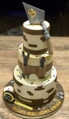 a three tiered birthday cake decorated with tools