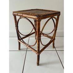 a small table made out of rattan and wicker with a square wooden top