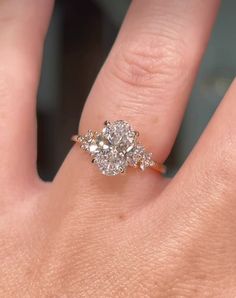 a woman's hand with a three stone ring on top of her finger,