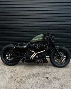 a black motorcycle parked in front of a garage door