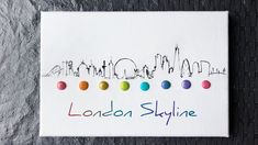 the london skyline embroidered onto a white piece of paper with colored dots on it and an inscription that reads london skyline