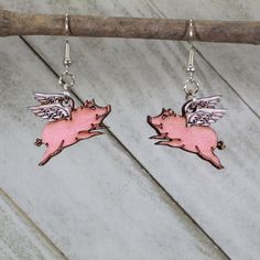 "\"When Pigs fly\" they do with these Realistic Flying Pig Dangle Earrings. This bovine jewelry is lightweight, hand-painted, hypoallergenic, and nickel free. Extremely lightweight Hypoallergenic, nickel-free All earrings are made from surgical steel Carefully cut from Birch for both beauty and strength Hand-painted Lifetime replacement for the cost of shipping Custom designs available, our motto is \"if you dream it, we will make it an earring.\"" Flying Pig Earrings, Pig Jewelry, Pig Earrings, Peace Sign Hand, Peace Earrings, Cute Piglets, Pigs Fly, Pig Lovers, Flying Pig